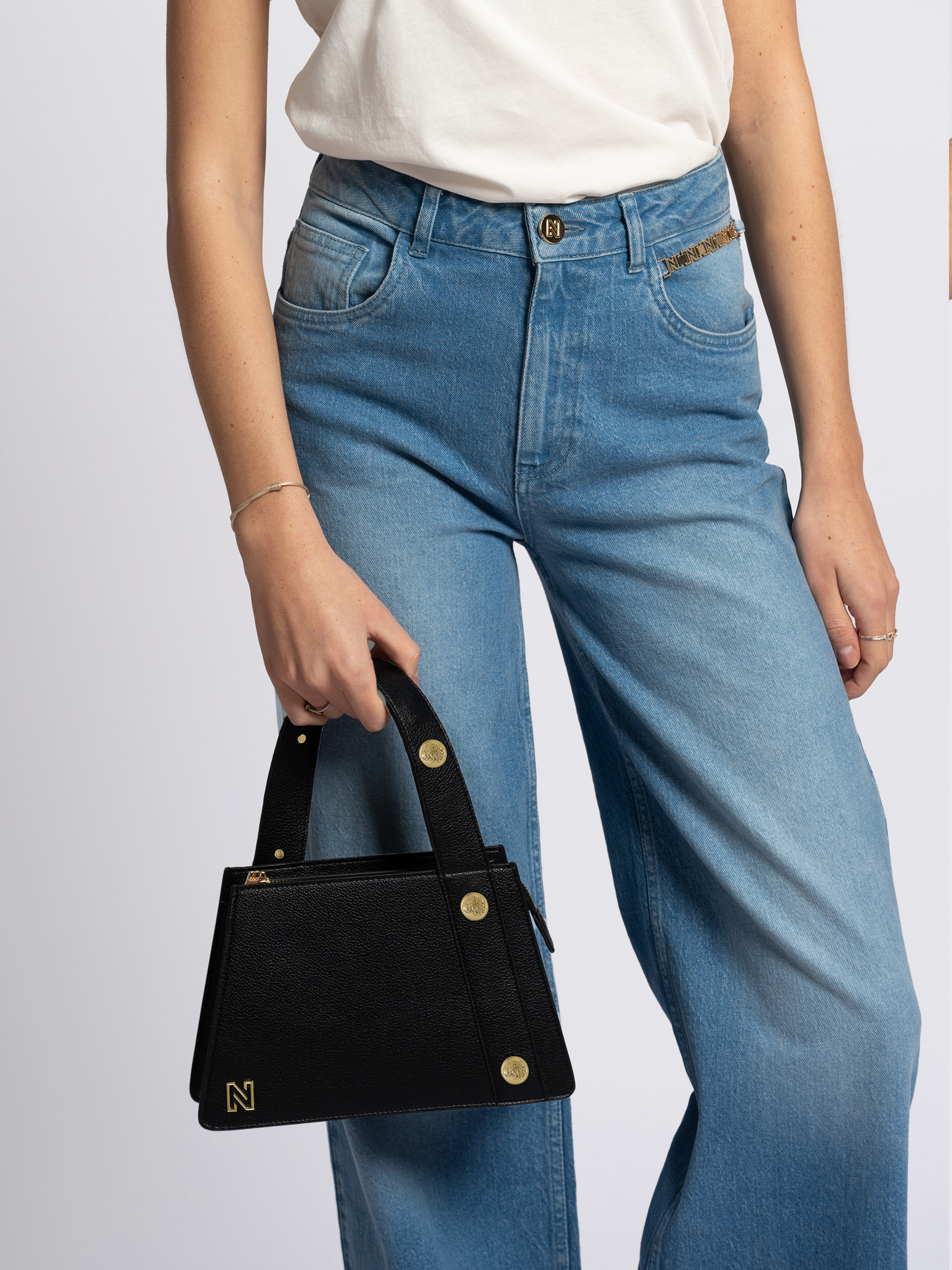 Bag with asymmetrical handle and decorative buttons