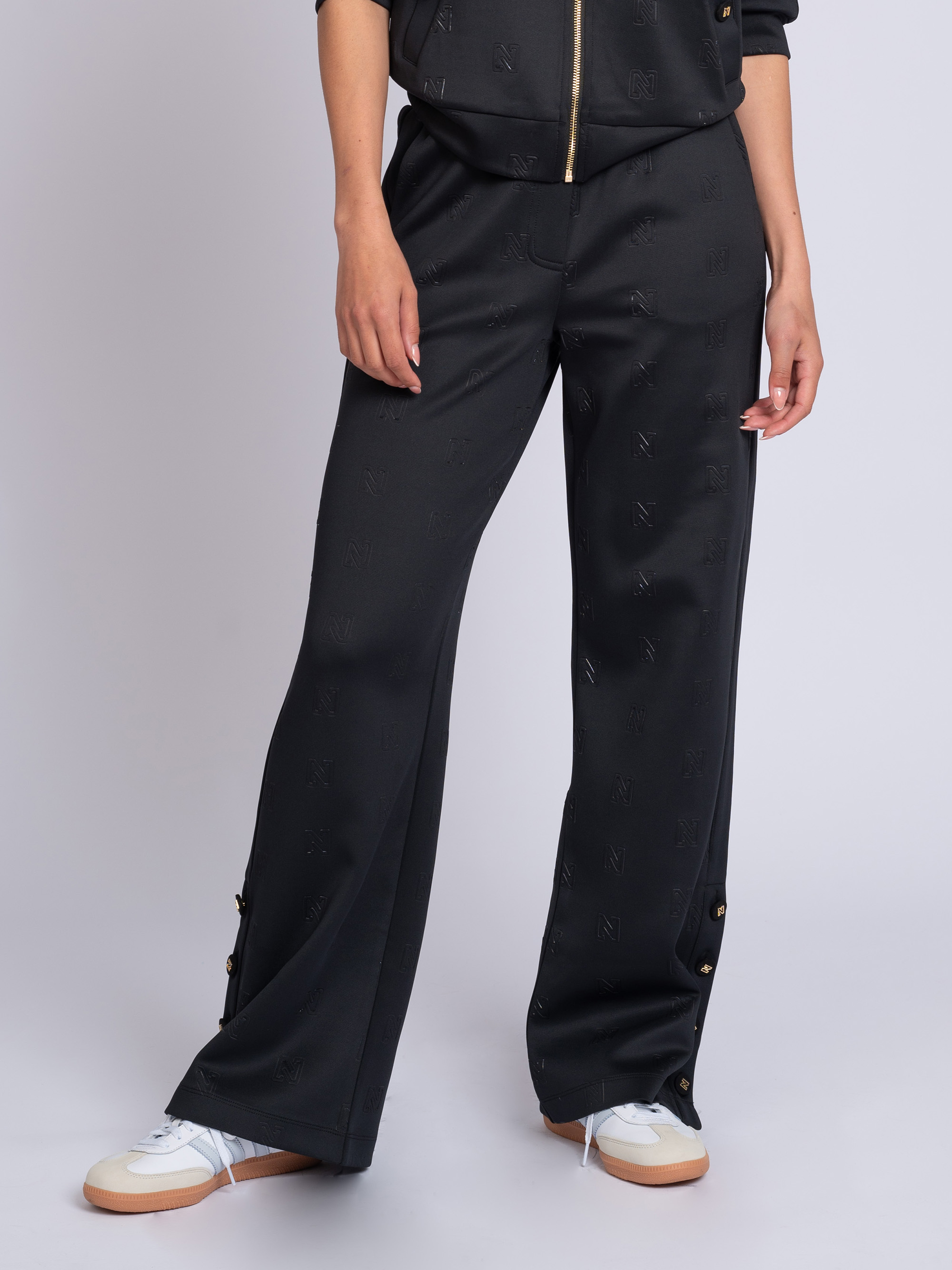 Loose-fitting pants with logo pattern and decorative buttons